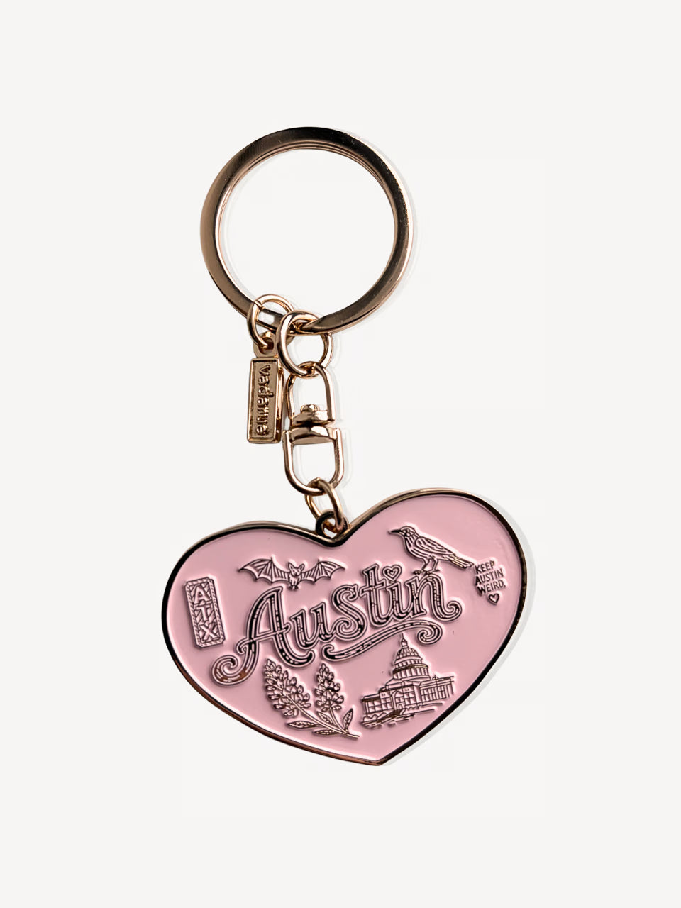 A pink heart-shaped metal keychain charm with 'Austin' and local landmarks engraved, attached to a gold-tone split ring and clasp, on a light gray background.